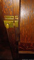 Close-up photo of brass latch hardware on antique tiger oak secretary desk