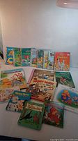 Lot of seventeen children's books including Little Golden Books and Disney titles. Books are arranged on a flat surface and show colorful illustrated covers.