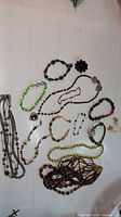 Full assortment of beaded jewelry laid out showing various necklaces, bracelets, and a brooch.