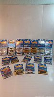 Front view of 30 assorted Hot Wheels cars in original blue packaging arranged on a flat surface.