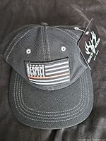 Front view of the black strapback hat with the embroidered American flag 'Respect' patch.