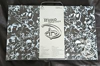 Box front and top view showing Disney Art Studio Collection branding and black and white Disney character sketches.