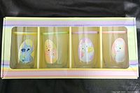 Front view of set in box showing all four glasses with Disney Easter designs.