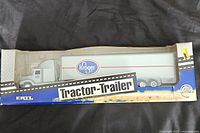 Front and side view of the Kroger Freightliner tractor-trailer diecast model in original box with visible box damage.