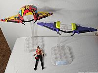 Two Fortnite gliders on display stands and one action figure placed in front