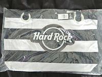 Front view of tote bag showing Hard Rock Cafe logo on black and white stripes with metal ring handle accents.