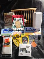 Full view of lot with wooden backrest, kitchen linens, vacuum bags, briefs, patches, and boxed beauty kit