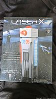 Front of the box showing Laser X Gaming Tower branding, toy image, and features.