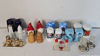 Overview of assorted salt and pepper shakers in various styles and materials arranged in a row