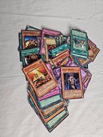 Pile of assorted Yugioh cards showing fronts of monster and spell cards.