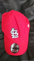 Front view of red New Era hat showing St Louis Cardinals embroidered logo and size sticker.