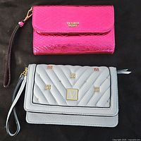 Two wristlets side by side; pink metallic snakeskin textured and embroidered light gray quilted wristlet