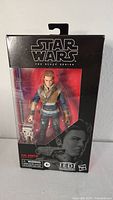 Front view of the unopened Star Wars Black Series Cal Kestis figure in box, showing the figure and droid accessory inside clear packaging with branding details.