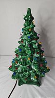 Full view of the green ceramic Christmas tree with colorful plastic lights.