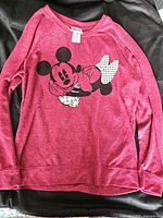 Full front view of pink/red long sleeve shirt with Mickey Mouse graphic.