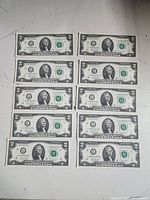 Ten sequential United States $2 bills front sides showing Thomas Jefferson portraits and serial numbers.