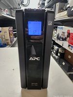 Front view showing APC brand and LCD display reading 121, indicating power on state.