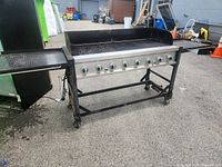 Front view of full grill showing control panel, side shelves, and stand