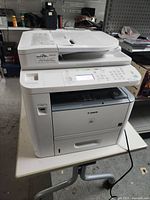 Front view of Canon ImageClass D1320 multifunction printer on table showing overall design and condition.