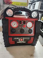 Front view of Centech 5 in 1 Portable Power Pack showing LED lights, pressure gauges, switches, and ports.