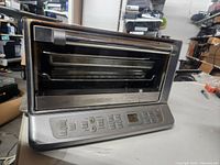Full view of the Cuisinart convection toaster oven showing stainless steel body, glass door, and control panel.