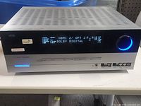 Front view of receiver powered on showing digital display and input selection.