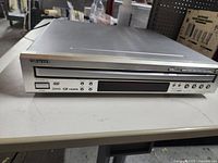 Front image of silver Onkyo multidisc DVD player on white table showing disc tray, control buttons, and brand logo.