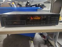 Front view of Pioneer PD-M410 CD player showing the disc tray, LED display with digital readout and multiple control buttons.