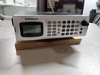 Front view of RadioShack Pro-2096 scanning receiver showing buttons, LCD screen, and antenna.