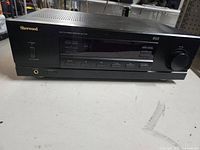 Front view of Sherwood stereo receiver showing power button, headphone jack, multiple control buttons and large volume knob, black color.