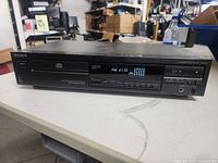 Front view of Sony CD player showing display screen and control buttons.