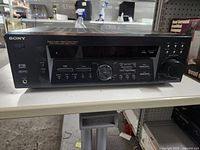 Front view of Sony AV Receiver showing control buttons, display, and knobs.