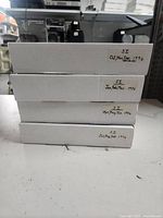 Four white storage boxes stacked, labeled with months and year 1996, containing Sports Illustrated magazines.