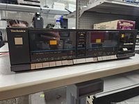 Front view of Technics stereo double cassette deck showing all buttons, cassette compartments and model details.