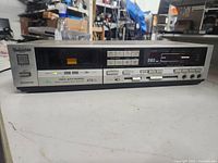 Front view of Technics RS-B49R stereo cassette deck, shows playback controls, cassette window, branding and model info on front.