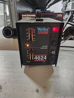 Front view of Weller soldering station showing model number 4624 and power indicators, control switches, and soldering iron holders.
