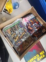 Full bankers box showing several Wizard magazines featuring vibrant comic book covers of fantasy and superhero characters.