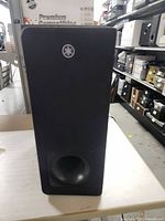 Front view of Yamaha wireless subwoofer with Yamaha logo on grille and bass reflex port.