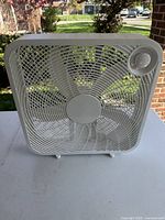 Front view of white 20-inch box fan showing blades, grill, and control dial