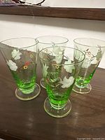 four green hand painted wine glasses grouped