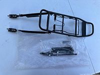 Rear rack and sealed bag of mounting hardware laid on table