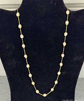 Full view of pearl station necklace on display bust