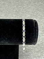 Front view of bracelet showing alternating purple and clear stones