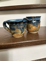 Front view of both pottery pieces showing glaze and shape