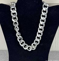 Full view of heavy curb link silver tone necklace displayed on bust