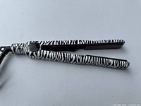 Full view of zebra-print hair straightener closed
