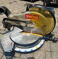 Front view showing Ryobi logo, 12-inch blade, angle scale