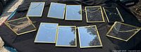 All 10 gold-tone square frames with chains displayed on black cloth