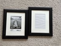Front view of both black 8x10 frames, one with display insert, showing mats and frame style