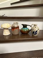 All four miniature pottery pieces displayed on step